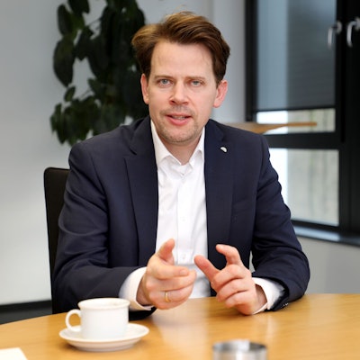 Landrat Arne von Boetticher sitzt in seinem Büro an einem Tisch.