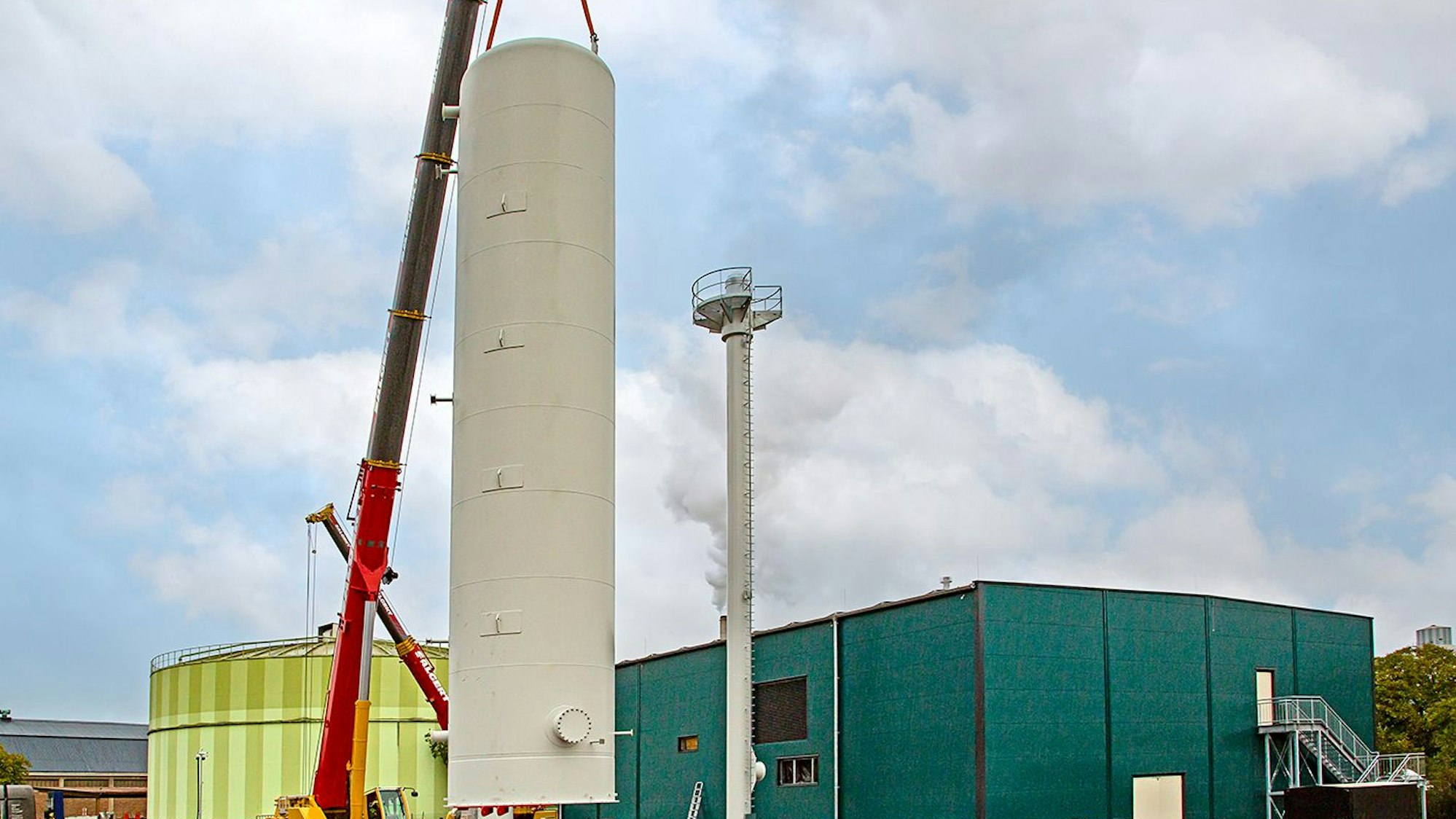 Einer der Kräne hievt den Behälter in die Höhe, der andere ist im Hintergrund zu sehen.