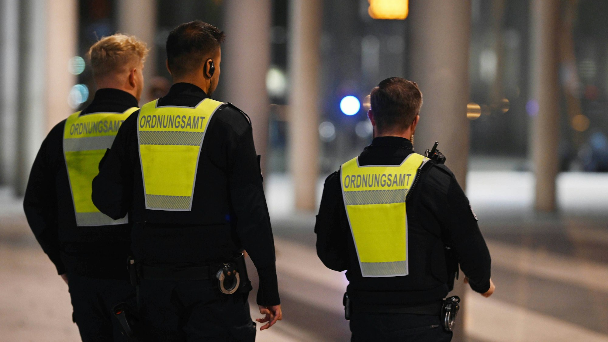 Drei Ordnungsamt Beamte gehen mit Warnwesten.