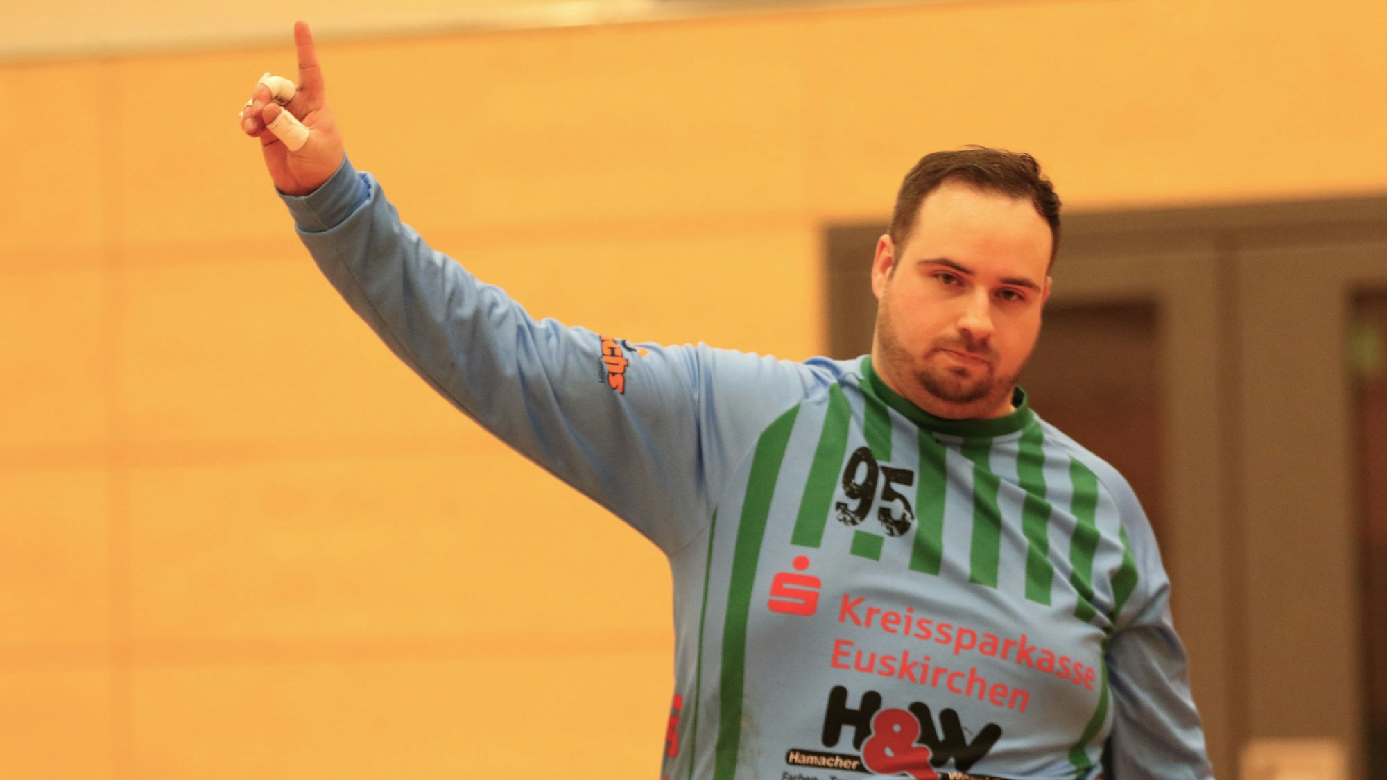 Das Bild zeigt Andre Jonas, der den Zeigefinger der rechten Hand nach oben streckt.