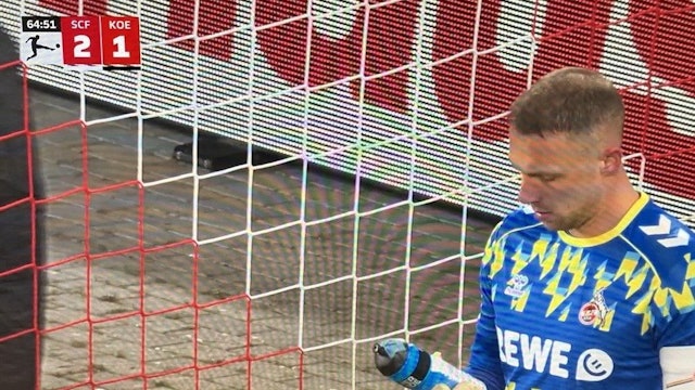 Marvin Schwäbe blickt auf seine Trinkflasche, an der ein Zettel befestigt ist.