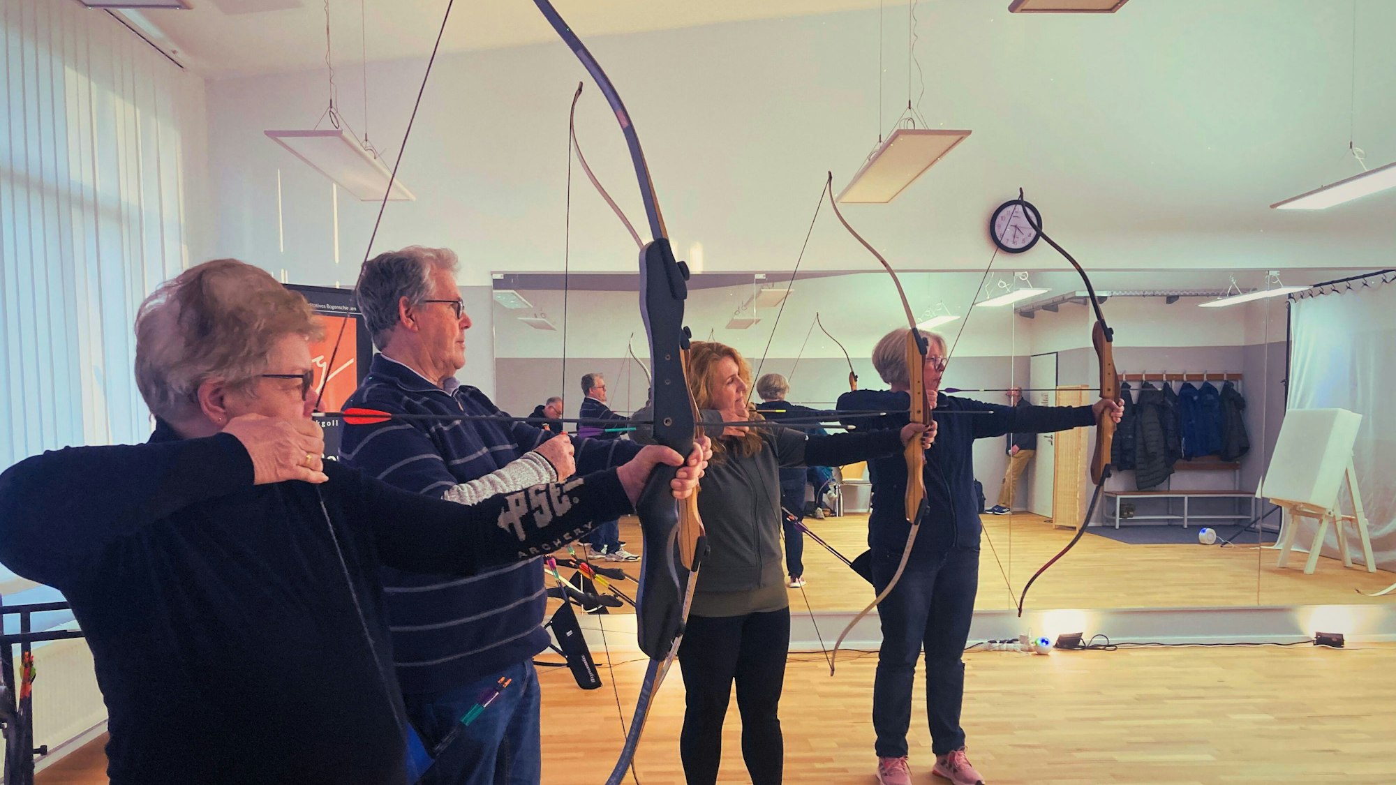 Mehrere Teilnehmer des VHS-Kurses lernen das meditative Bogenschießen.