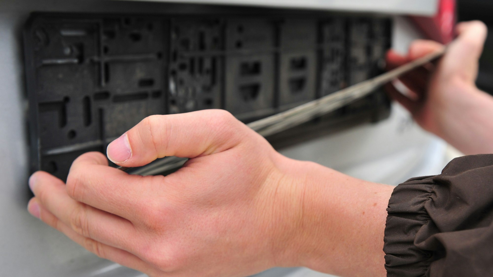 Ein Mann greift am Freitag (31.08.2012) in Stuttgart nach einem Autokennzeichen.