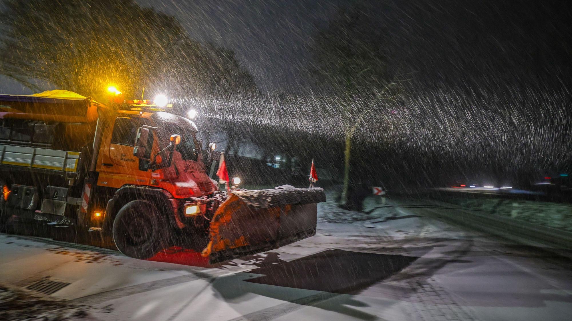 Herford: Ein Fahrzeug vom Winterdienst der Autobahnmeisterei fährt am Montagmorgen bei Schneetreiben auf einer Landstraße.