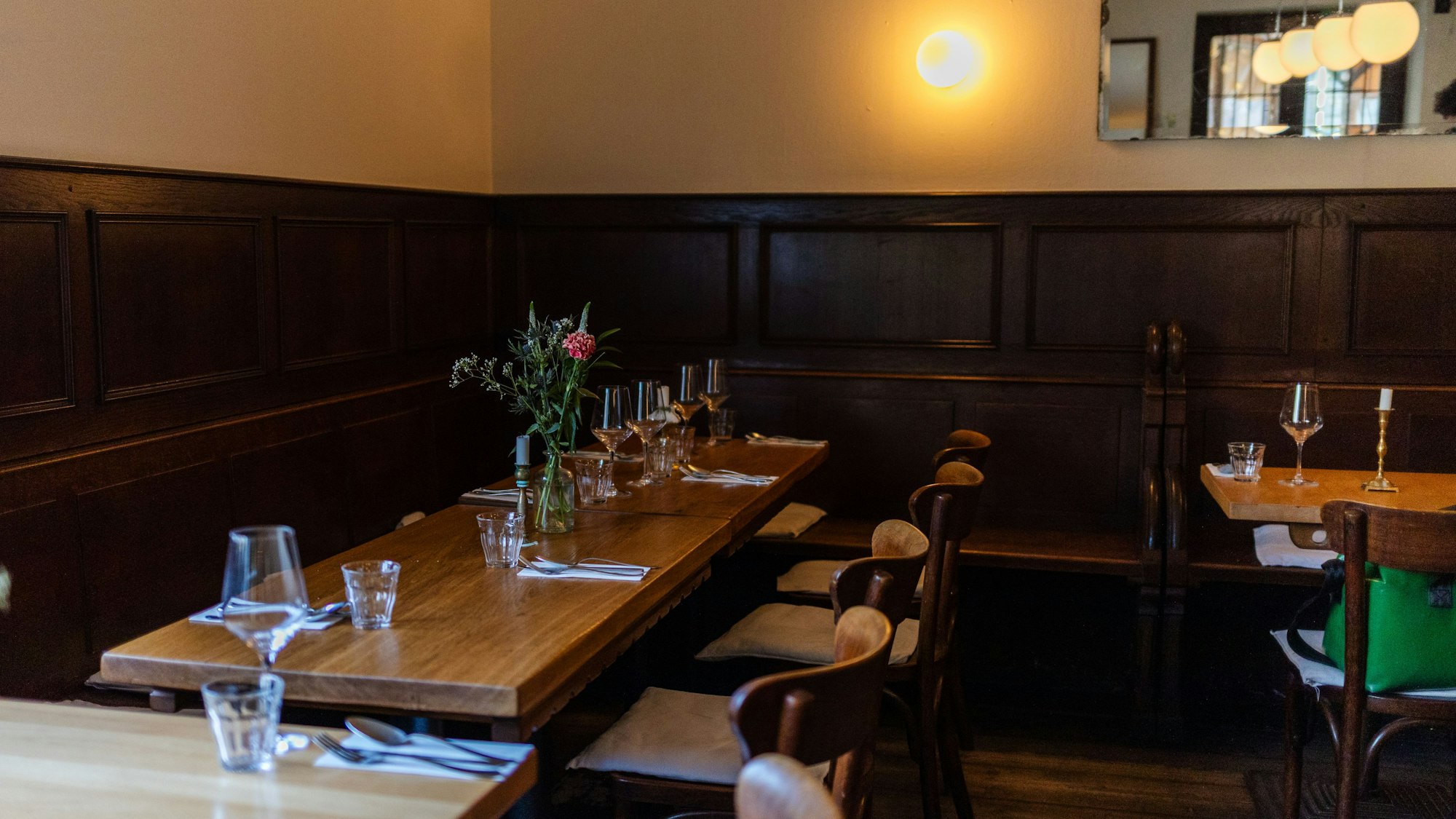 Der Blick ins Restaurant: dunkle Holzstische vor einer dunklen Vertäfelung an den Wänden.