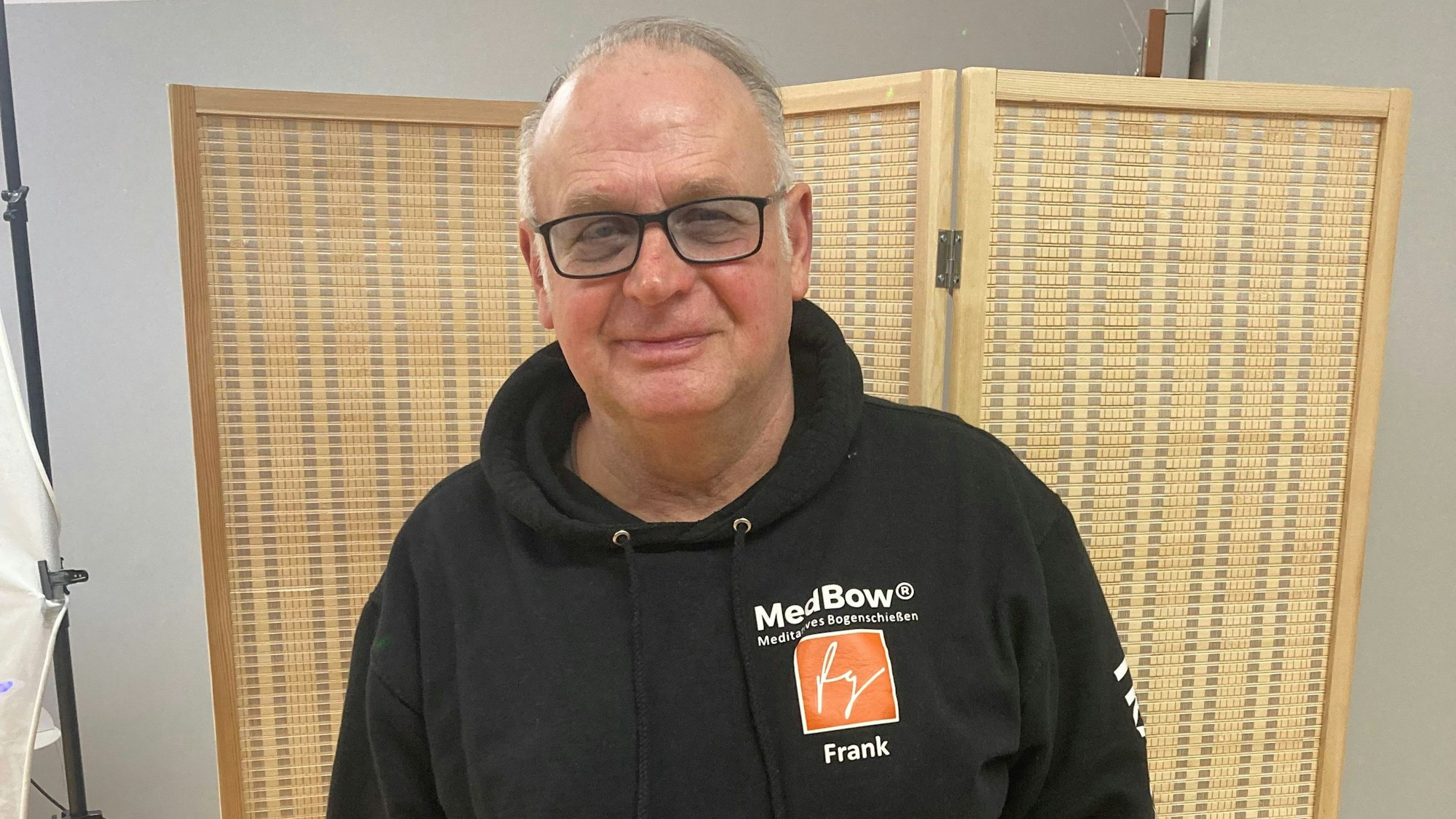 Ein Mann steht vor einer Stellwand.