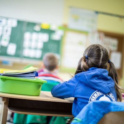 Schülerinnen und Schüler einer Grundschule sitzen in ihrem Klassenraum.