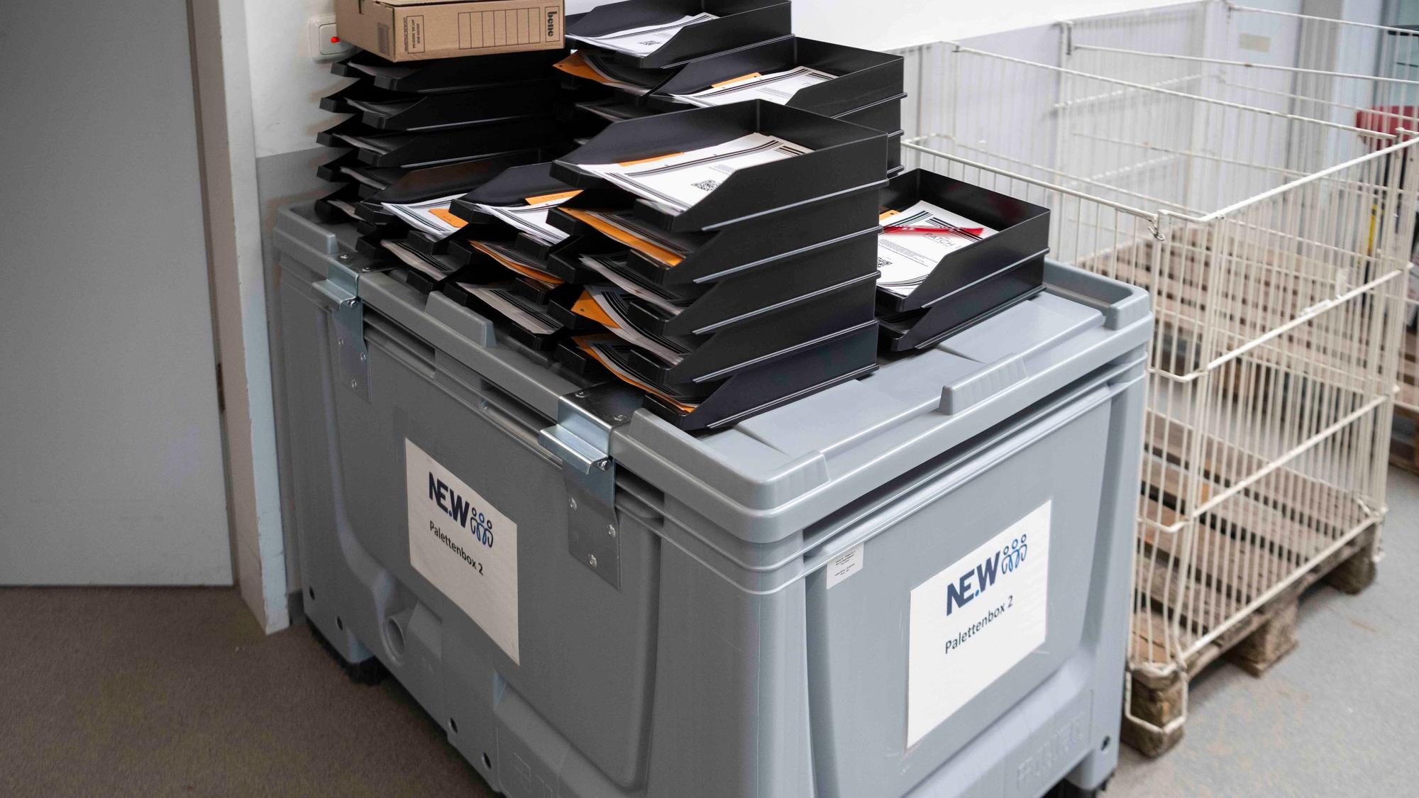 Das Bild zeigt eine recht große graue Box. Darauf stehen Aktenablagen.