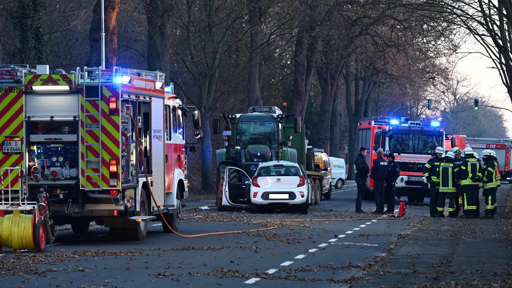 Nach dem Zusammenprall eines Kleinwagens und eines Traktors auf einer Straße sind Feuerwehr und Rettungsdienst im Einsatz.