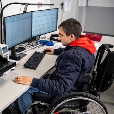 Das Bild zeigt einen Mitarbeiter der NEW, der vor einem Computer sitzt und Akten scannt.