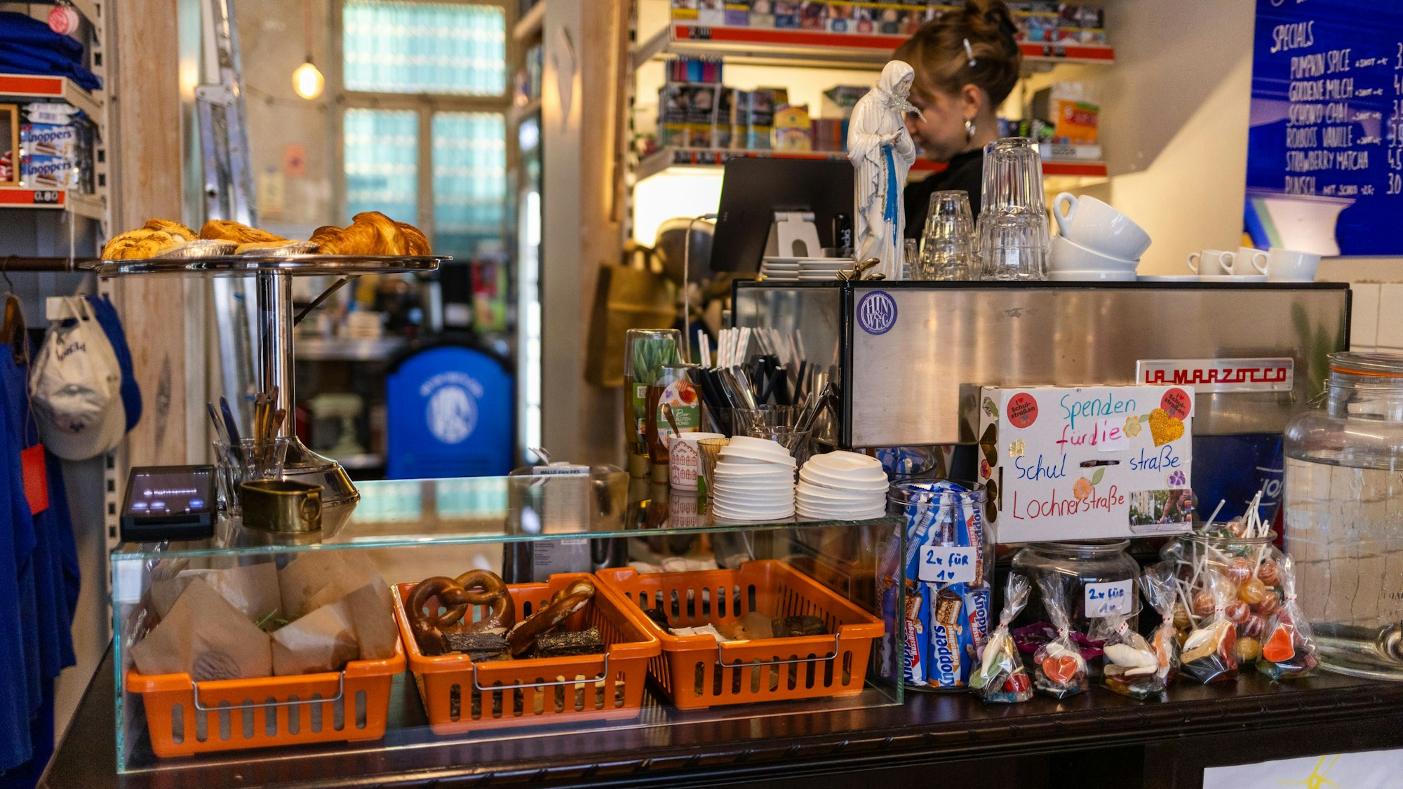 Blick auf die Theke: Brezeln in Körben, Süßigkeiten und Kaffeebecher.