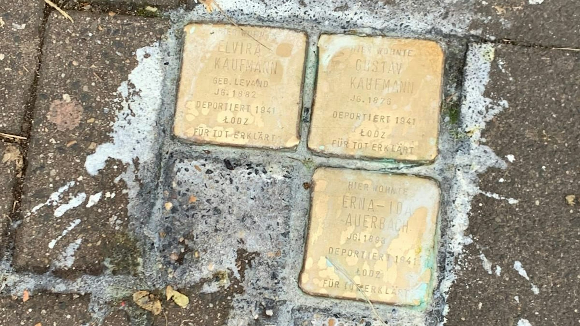 Drei Stolpersteine auf dem Mauritiussteinweg, die mit weißen Flüssigkeit übergossen wurden.
