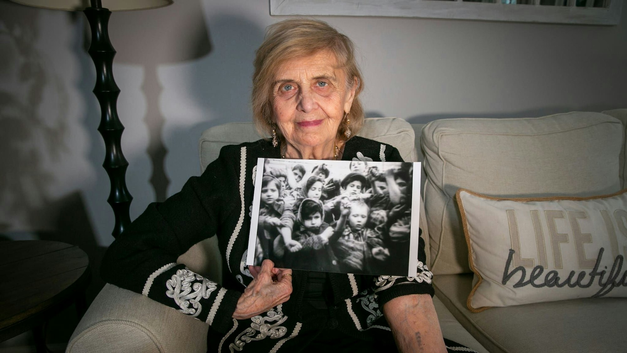 Die Holocaustüberlebende Tova Friedman zeigt ein Foto vom Tag der Befreiung des Konzentrations- und Vernichtungslagers Auschwitz 1945. Überlebende Kinder zeigen Rotarmisten ihre Häftlingsnummern. Sie ist das Mädchen ganz links. . Ted Shaffrey