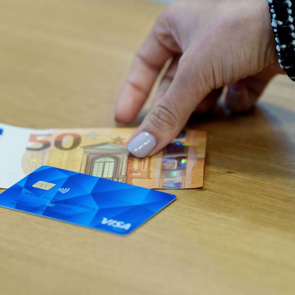 Eine Bezahlkarte für Asylbewerberinnen und Asylbewerber und ein 50 Euro Schein liegen nebeneinander.