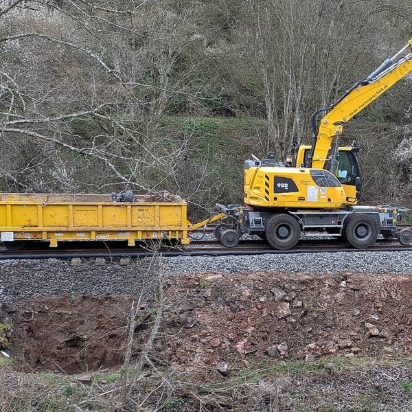 Ein Bauzug mit Bagger zieht einen Wagen (Archivbild).