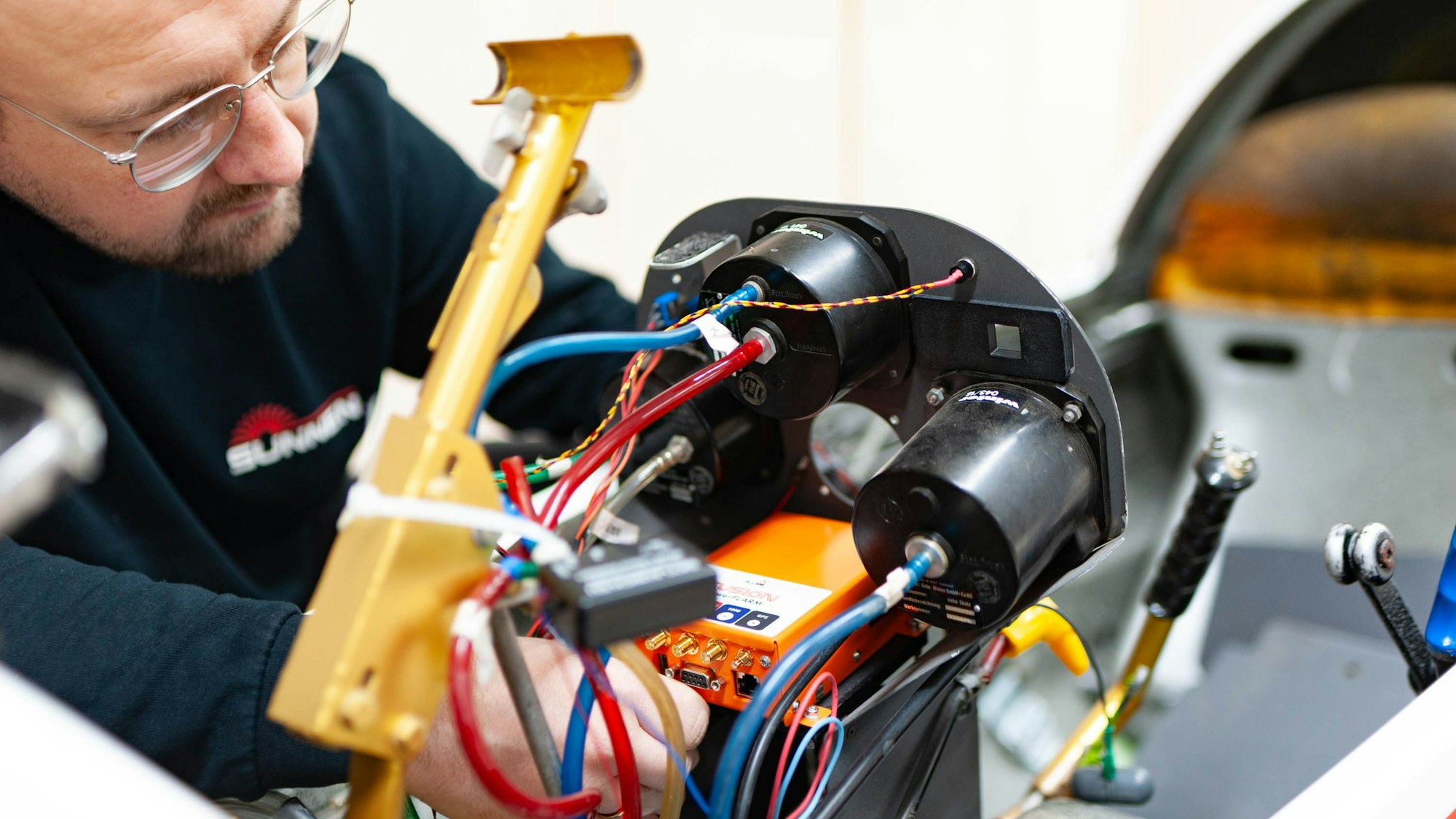 Eines der Mitglieder ist an den Kabeln im Cockpit zu Werke.