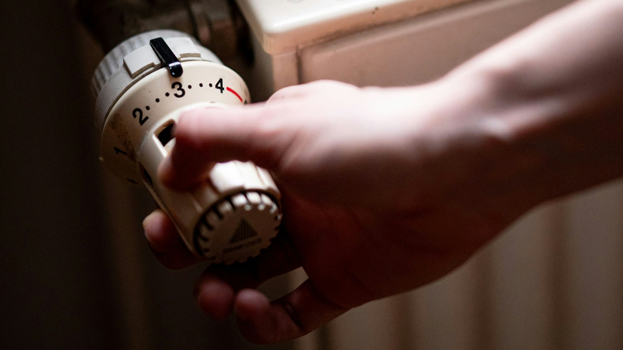 Eine Person benutzt einen Heizkörper in einer Altbauwohnung.