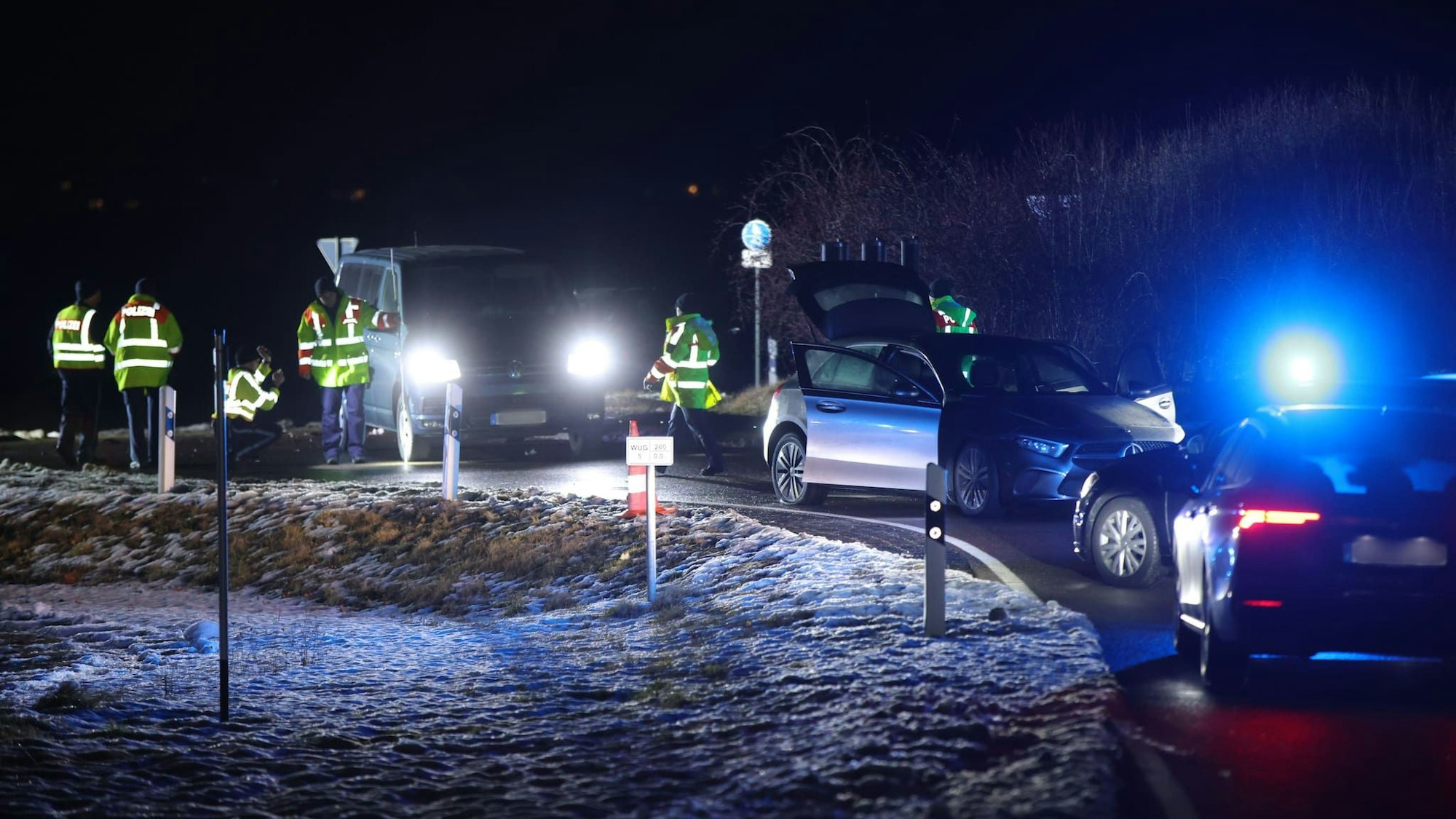 Fahrzeuge und Polizeikräfte stehen nach einer Verfolgungsjagd an einer Straße in Weißenburg.