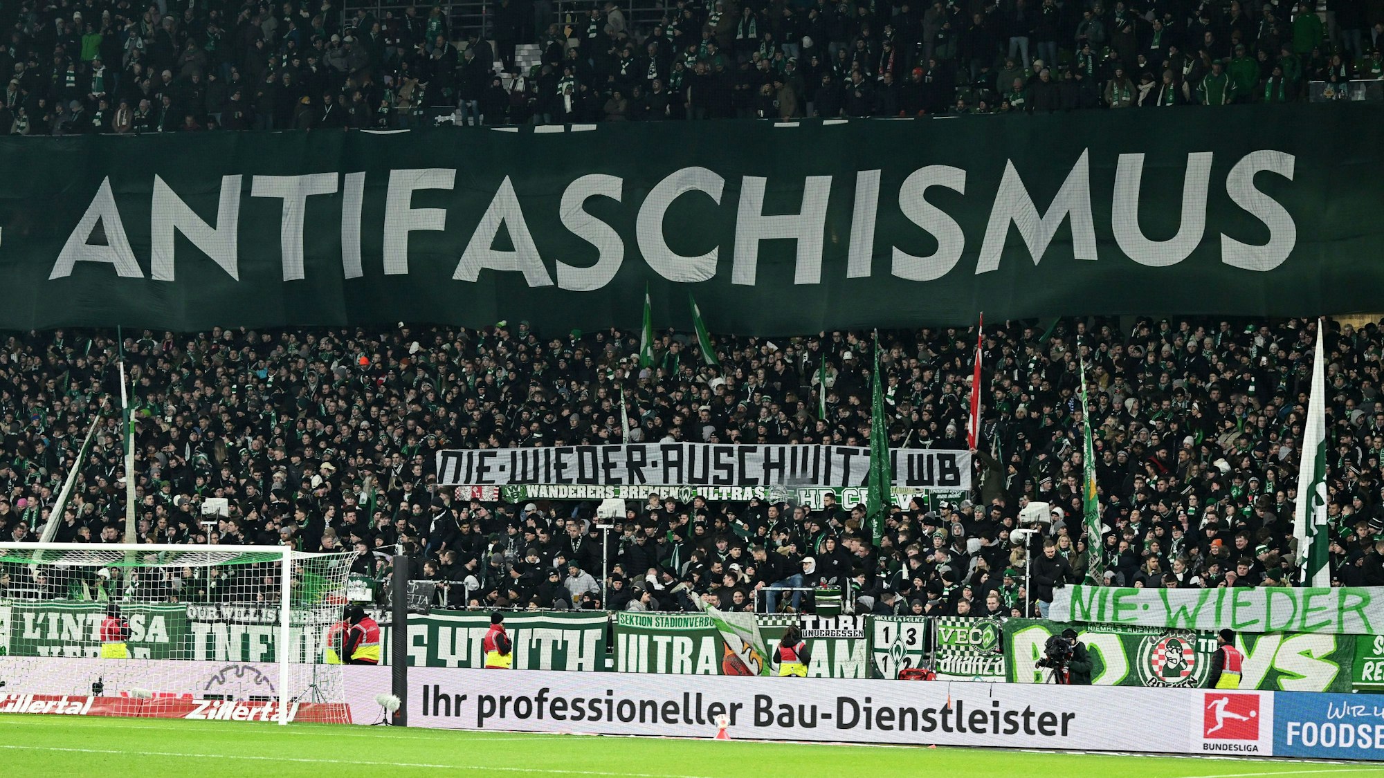 Das Bild zeigt Banner mit den Aufschriften „Antifaschismus“ und #nie wieder Auschwitz" die aus Anlass des Internationalen Tages des Gedenkens an die Opfer des Holocaust im Lager der Ultras von Werder Bremen beim Heimspiel gegen RB Leipzig am 27. Januar 2026 hochgehalten werden. Foto: Carmen Jaspersen/dpa
