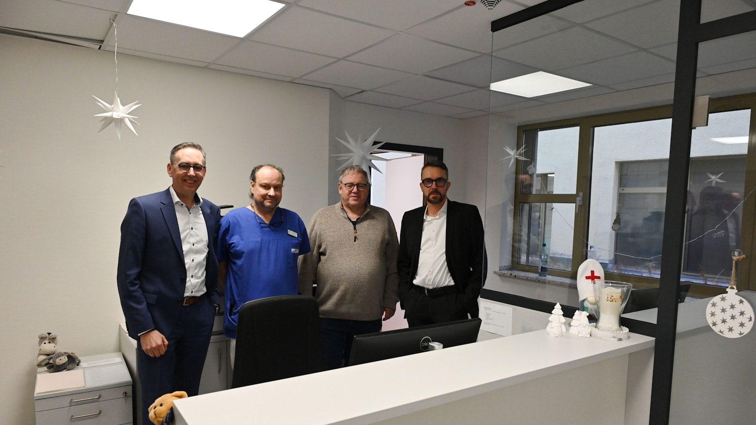 Vier Männer stehen hinter einem Tresen. Dort werden im Kreiskrankenhaus Mechernich künftig die Notfallpatienten ersteingeschätzt.