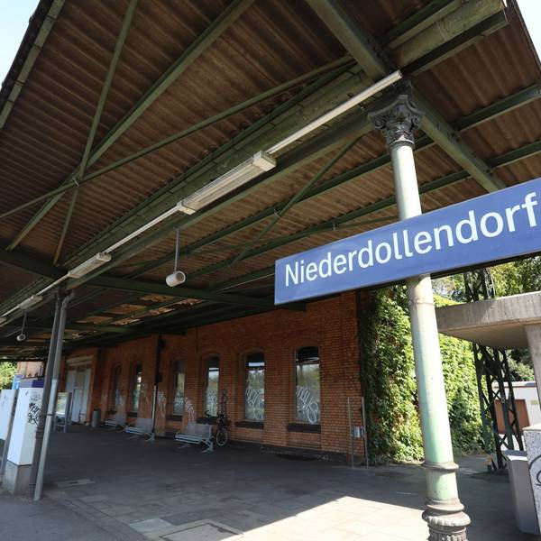 Gleis 1 vor dem Gebäude des Bahnhofes, an der Seite ein Schild mit dem Schriftzug Niederdollendorf.