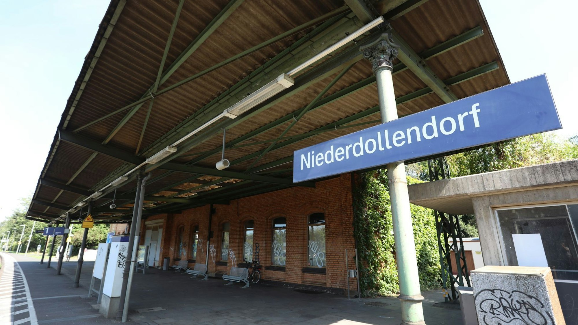 Gleis 1 vor dem Gebäude des Bahnhofes, an der Seite ein Schild mit dem Schriftzug Niederdollendorf.