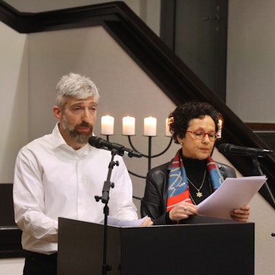 Ein Mann und eine Frau an einem Pult.