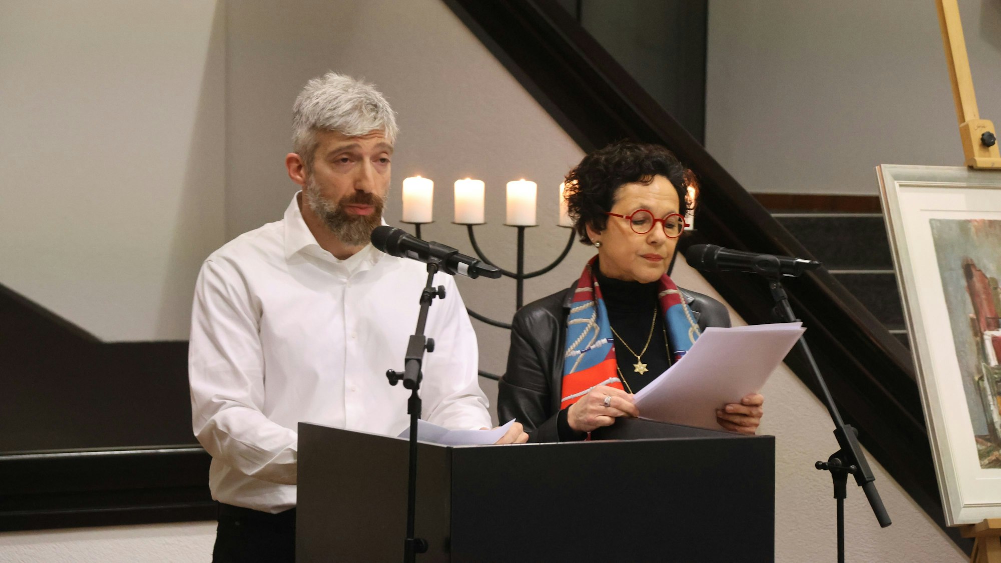 Ein Mann und eine Frau an einem Pult.