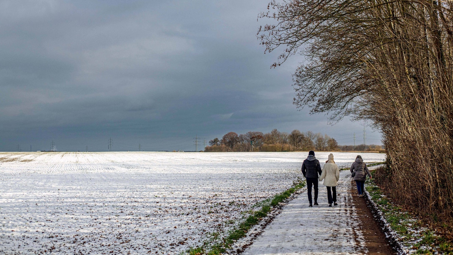 Drei Wanderer in verschneiter Winterlandschaft