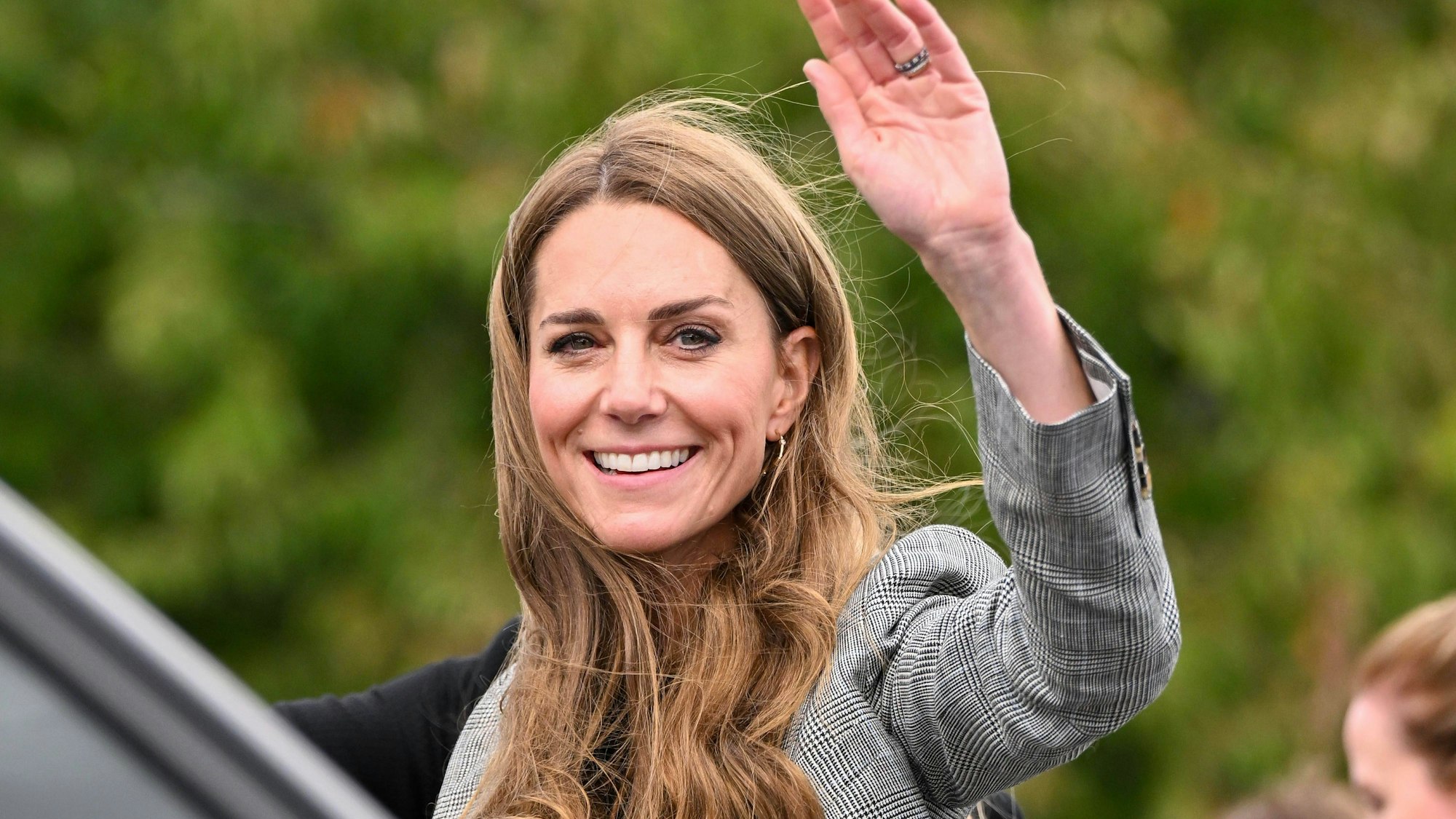Prinzessin Kate lächelt und winkt.