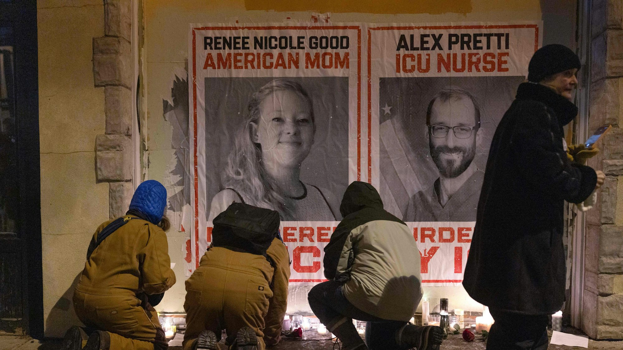 Das Bild zeigt Menschen, die vor Plakaten der getöteten Renee Good und Alex Pretti in Minneapolis Kerzen anzünden. Foto: Scott Olson/Getty Images via AFP)