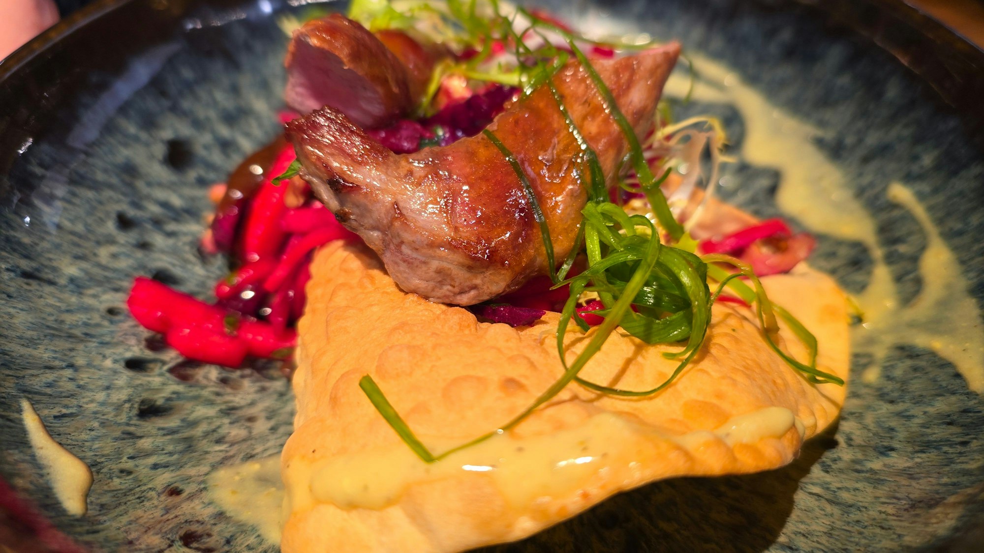 Auf einem Teller ist das Fleisch auf einem großen Papadam-Chip zu sehen.