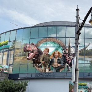 Entwürfe auf den Scheiben eines Gebäudes zeigen im Großformat zwei Kinder sowie Dinosaurierdarstellungen.