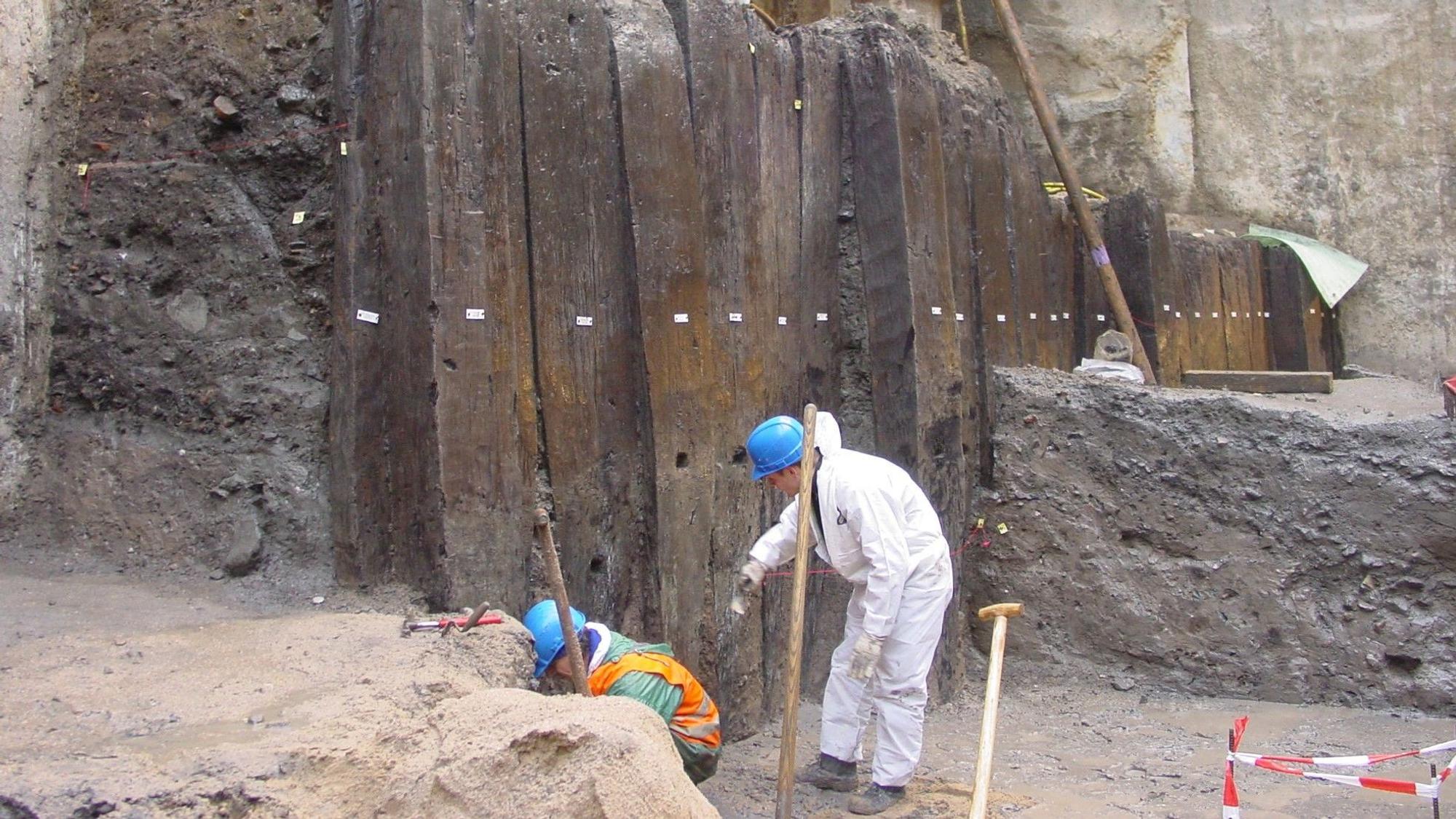 Archäologen vor einer römischen Pfahlwand