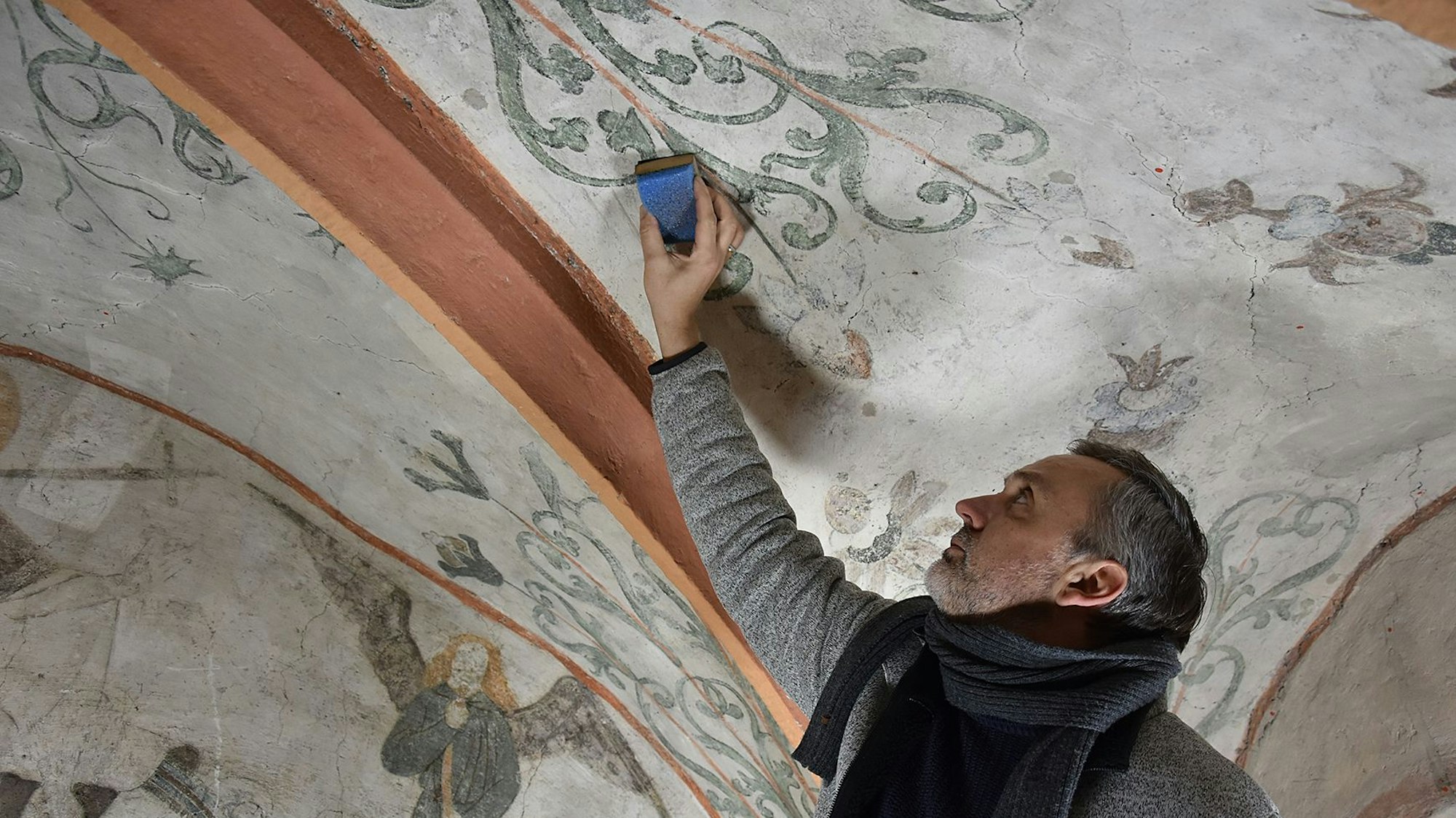 Das Foto zeigt Restaurator Christian Rubin bei der Arbeit in der Kirche in Nümbrecht-Marienberghausen.