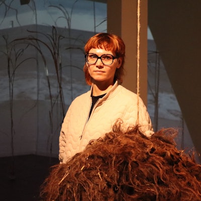 Frau in einem Raum vor Schafsfell