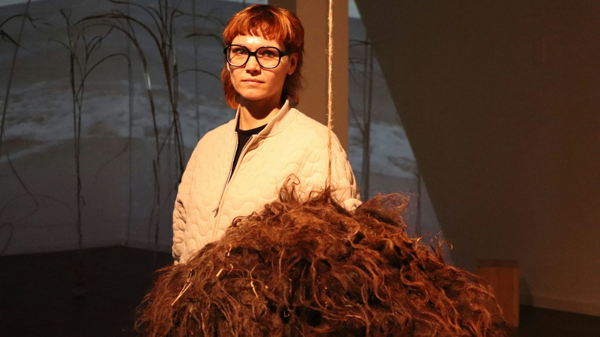 Frau in einem Raum vor Schafsfell