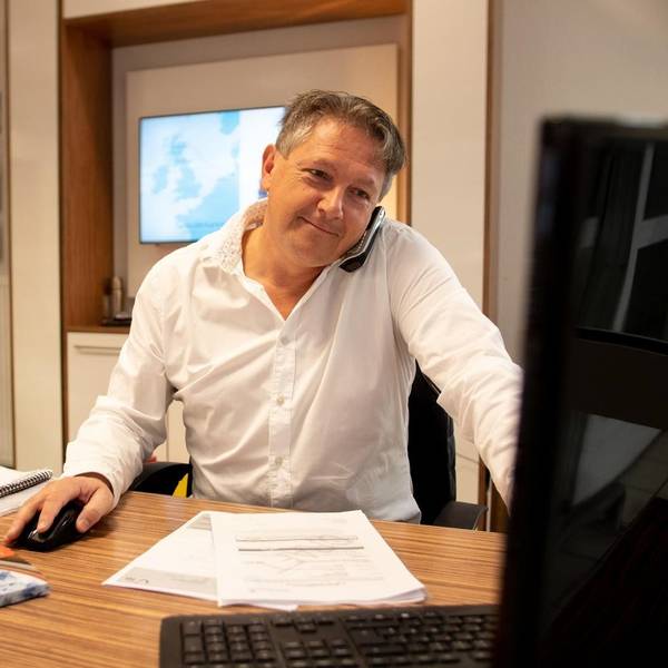 Das Bild zeigt Markus Birkenheuer an seinem Schreibtisch. Er sitzt vor einem Computer.
