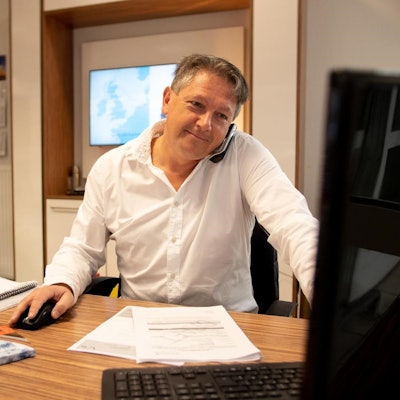 Das Bild zeigt Markus Birkenheuer an seinem Schreibtisch. Er sitzt vor einem Computer.