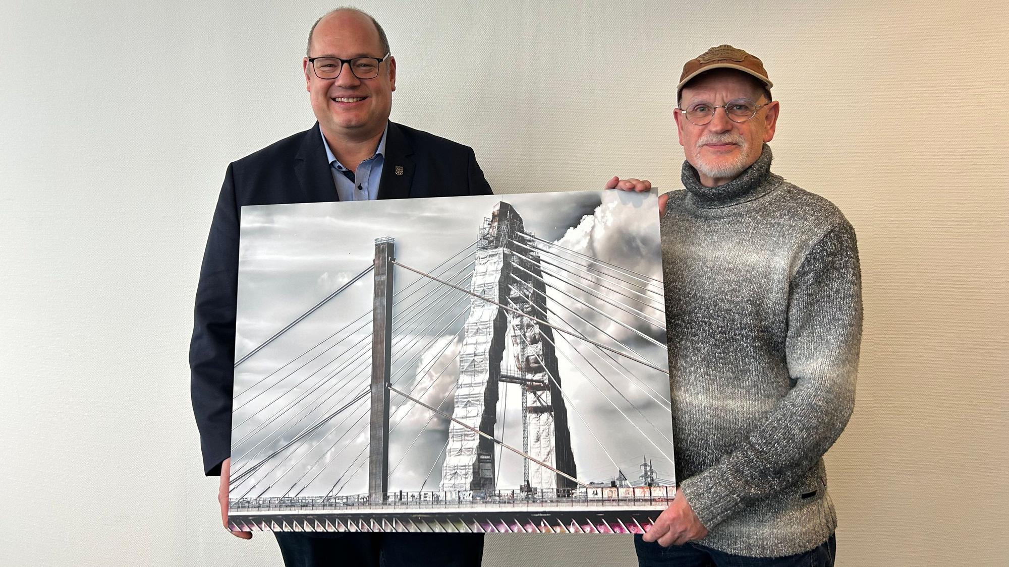 Leverkusens Oberbürgermeister Stefan Hebbel (links) freut sich über die Dauerleihgabe von Fotokünstler Michael Bork