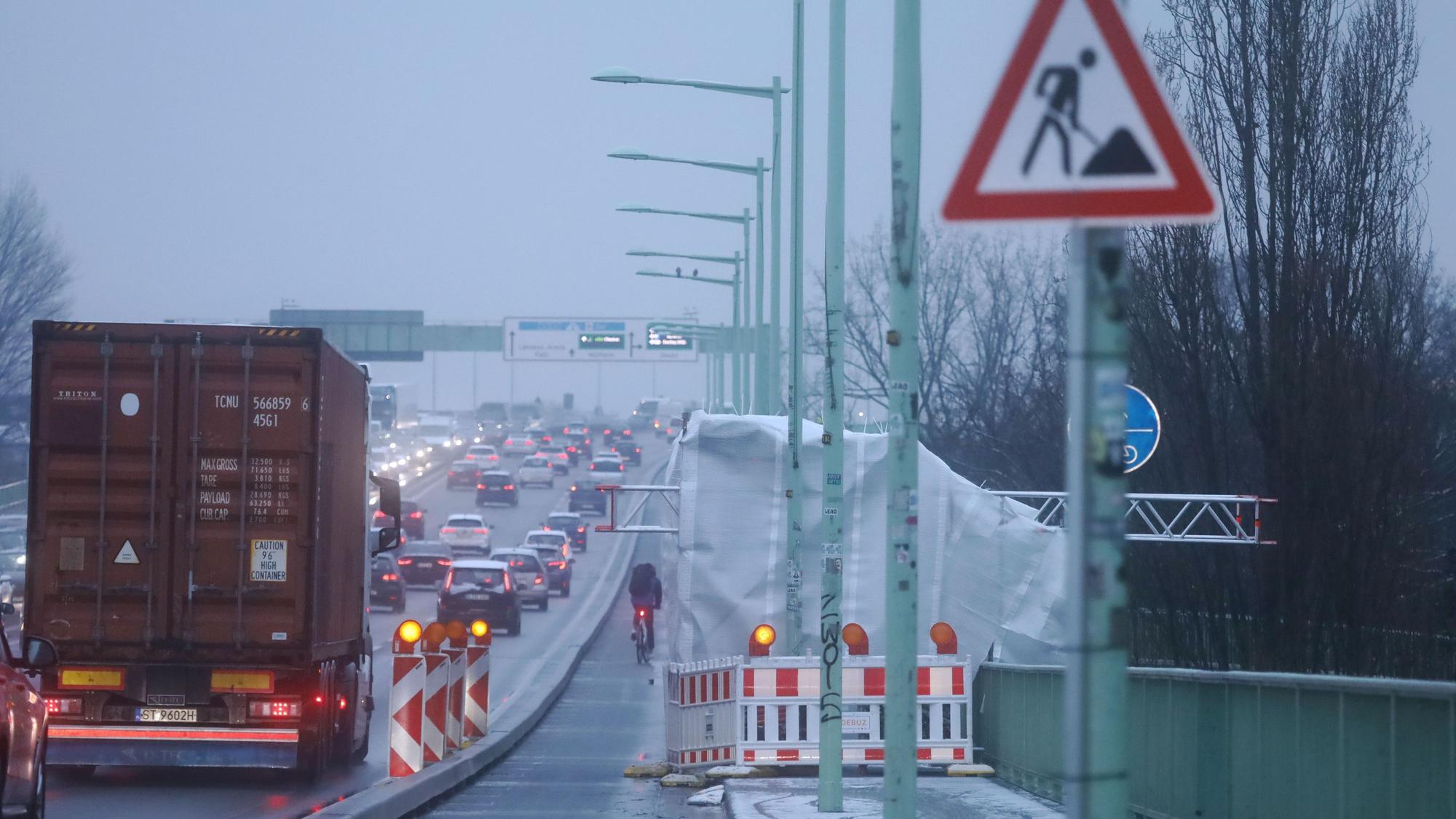 Aus Zeltplanen und Gerüststangen haben Arbeiter auf der Zoobrücke kleine Wärmezelte errichtet, unter denen die Standorte der künftigen Blitzer erwärmt werden.