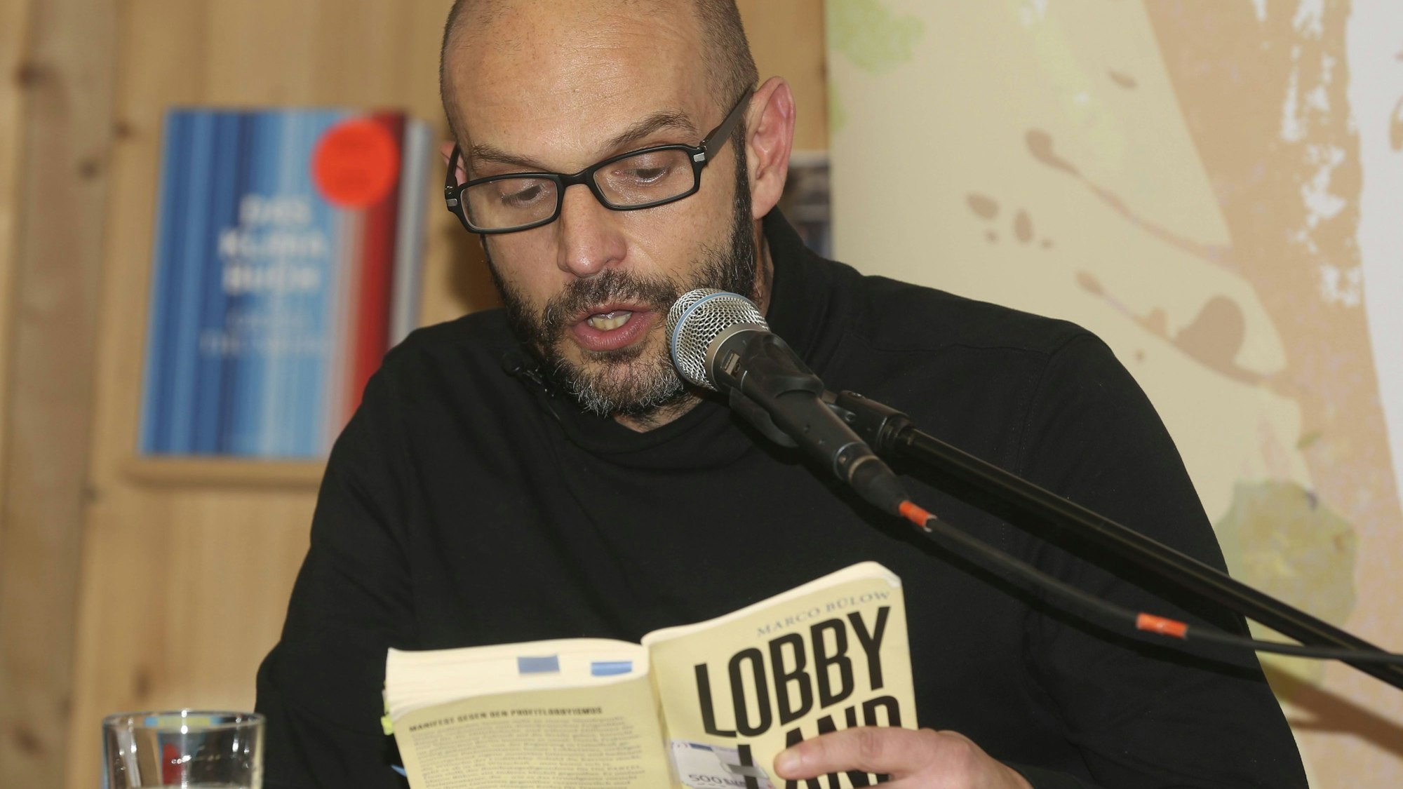 Marco Bülow liest aus einem Buch ins Mikrofon
