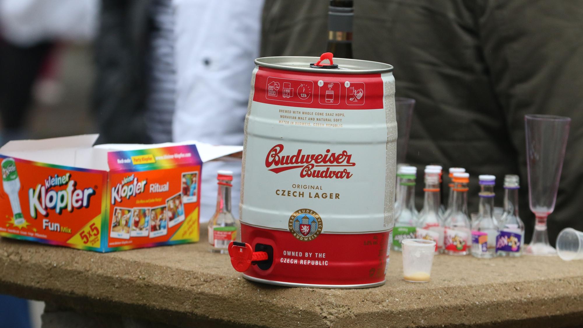 Ein Bierfass steht auf einem Tisch, dahinter kleine Schnapsflaschen.