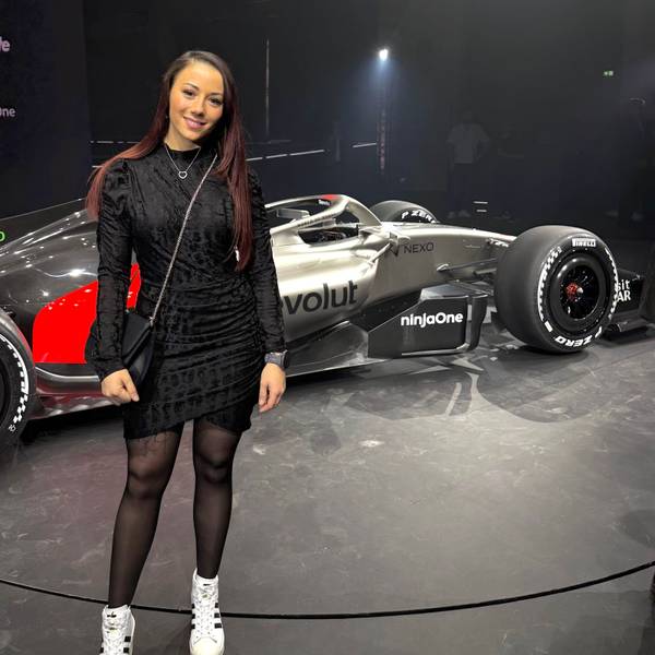 Carrie Schreiner steht vor dem Formel-1-Auto von Audi.