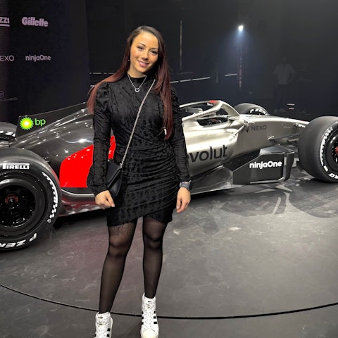 Carrie Schreiner steht vor dem Formel-1-Auto von Audi.
