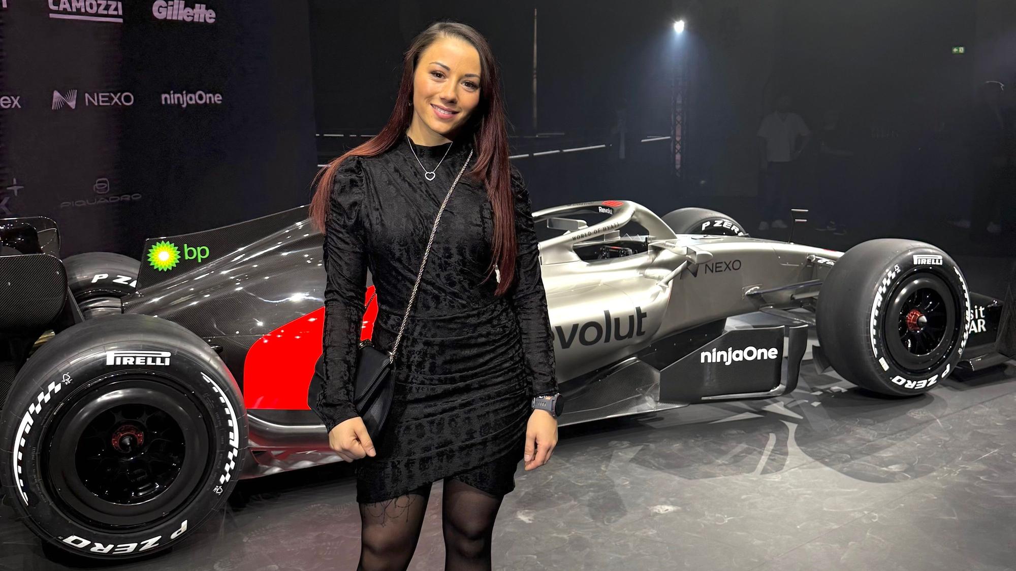 Carrie Schreiner steht vor dem Formel-1-Auto von Audi.