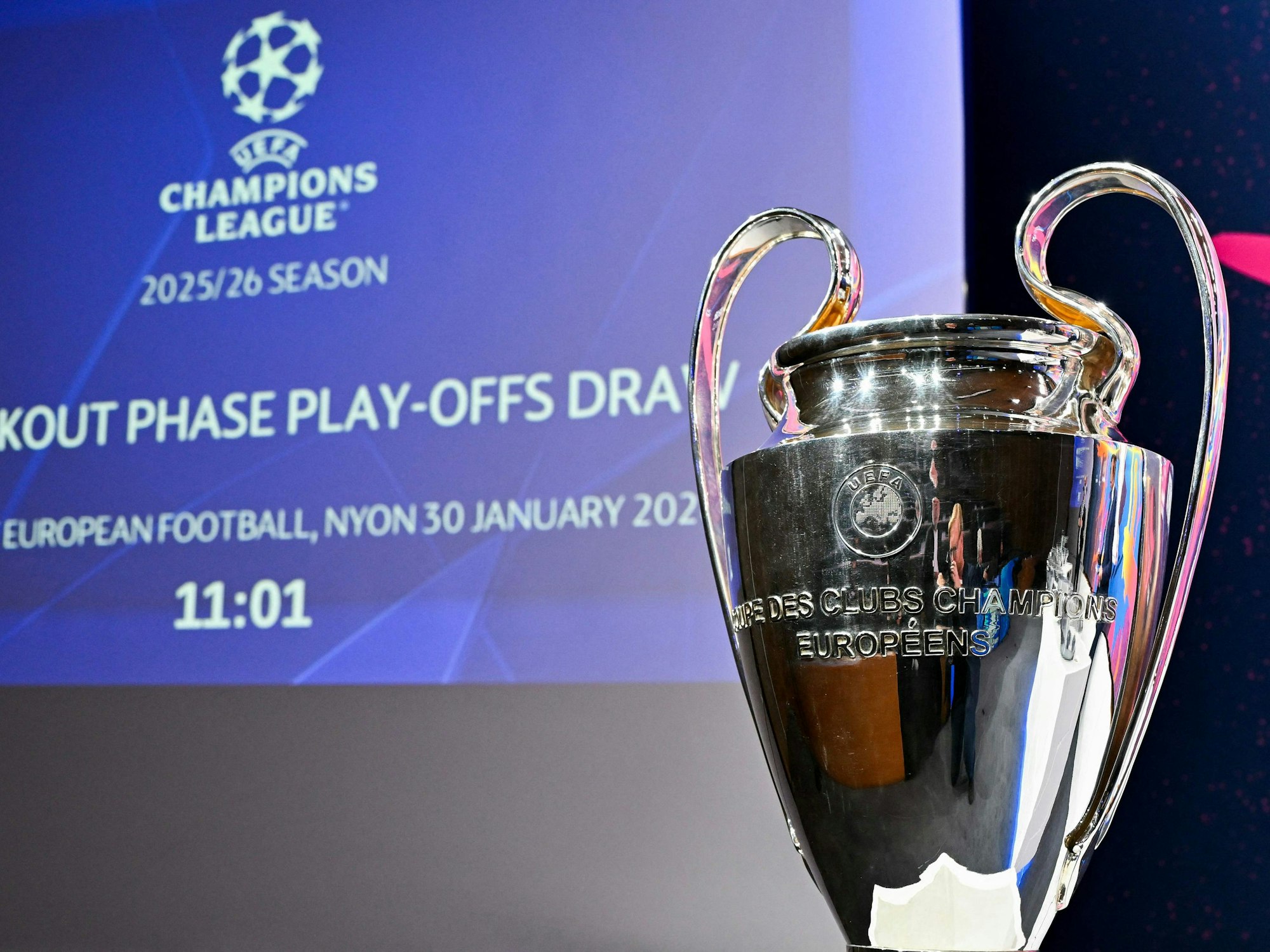 Die Champions-League-Trophäe steht vor einem Bildschirm.