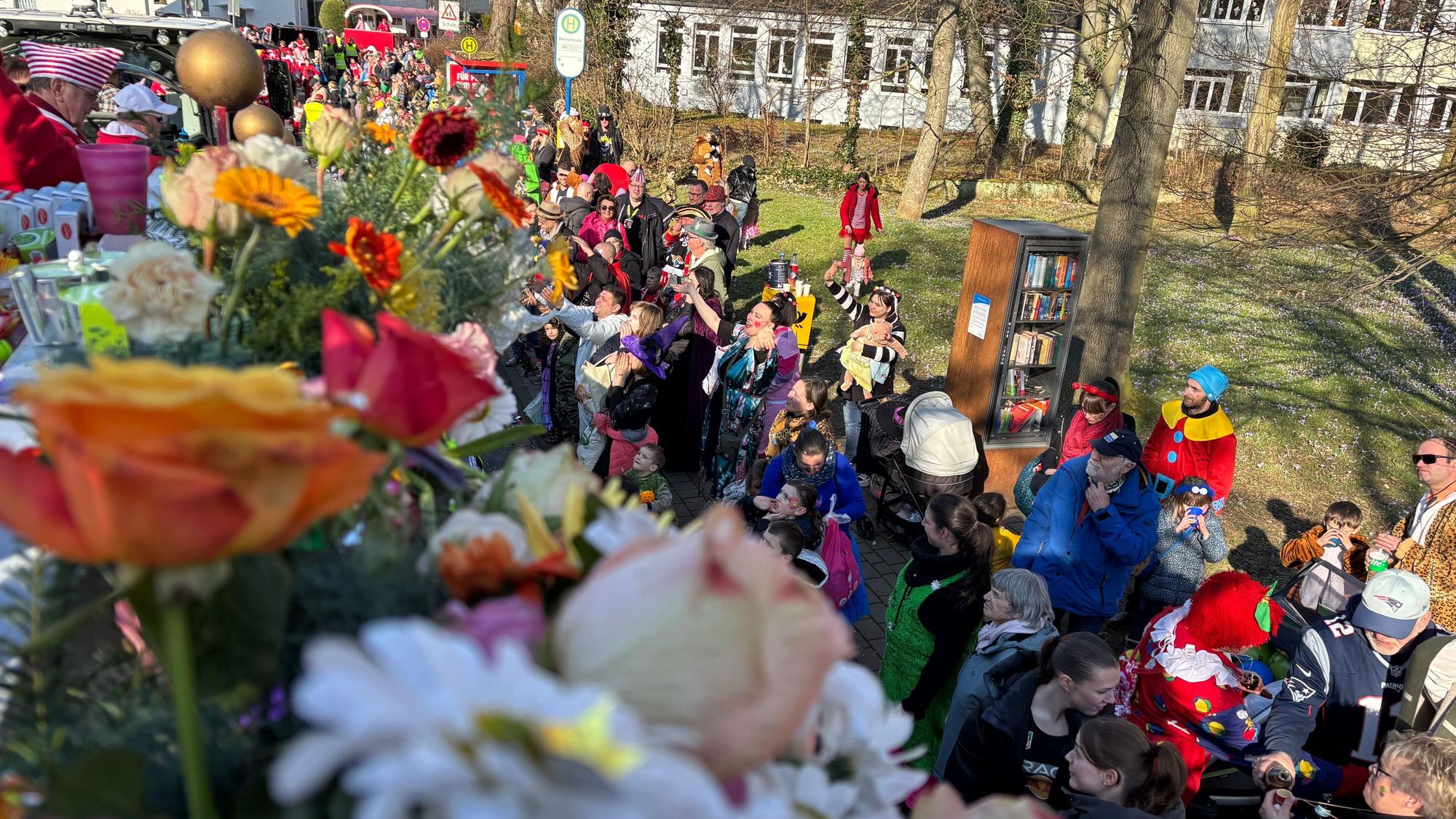 Der Karnevalszug geht durch Troisdorf. Am Straßenrand stehen verkleidete Menschen.