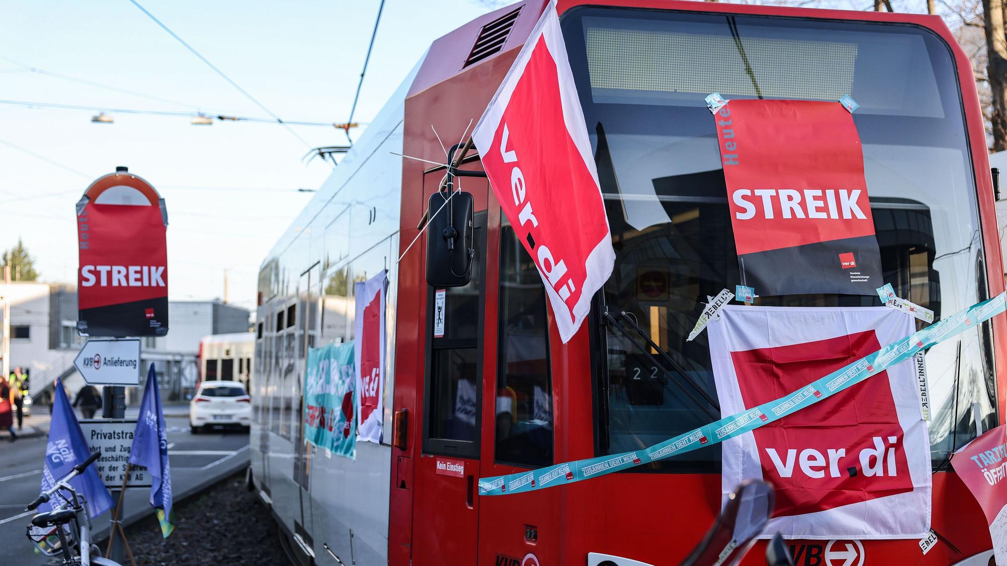 Eine mit Streik-Plakaten beklebte Straßenbahn der Kölner Verkehrs-Betriebe (KVB) steht vor dem Bahndepot.