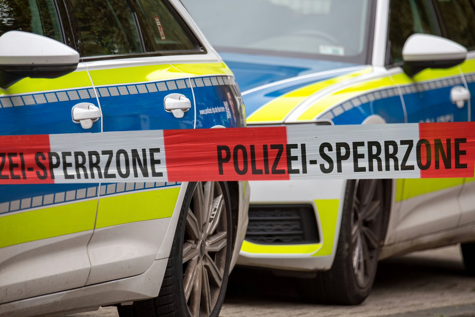 Absperrband der Polizei vor Einsatzfahrzeugen